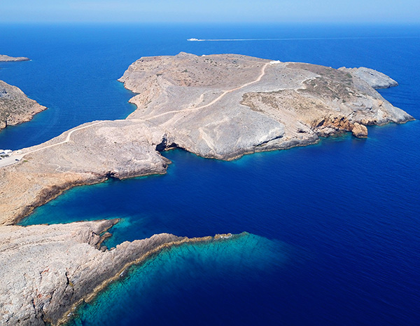 Aerial drone bird's eye view photo of picturesque bay and natural fjord of Heronisos with traditional fishing boats, taverns and clear water beach, Sifnos island, Cyclades, Greece